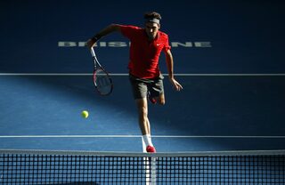 Federer of Switzerland plays a shot at the net during his men's singles semi final win over Dimitrov of Bulgaria at the Brisbane International tennis tournament in Brisbane
