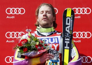 Kjetil Jansrud of Norway listens to the Norwegian anthem after winning the World Cup downhill trophy in the men's downhill race at the Alpine Skiing World Cup Finals in Meribel