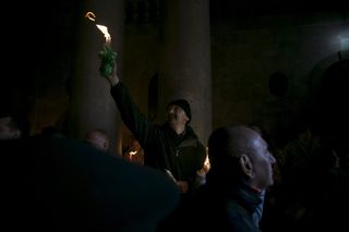 A worshipper holds a candle as he takes part in the Christian Orthodox Holy Fire ceremony at the Church of the Holy Sepulchre in Jerusalem's Old City