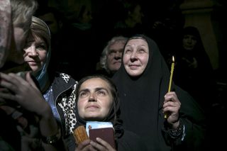 Worshippers hold candles aduring the  Holy Fire ceremony at the Church of the Holy Sepulchre in Jerusalem's Old City