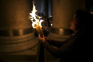 A Worshipper light candles during a Holy Fire ceremony at the Church of the Holy Sepulchre in Jerusalem's Old City