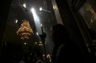 A worshipper holds a candle as she takes part in the Christian Orthodox Holy Fire ceremony at the Church of the Holy Sepulchre in Jerusalem's Old City
