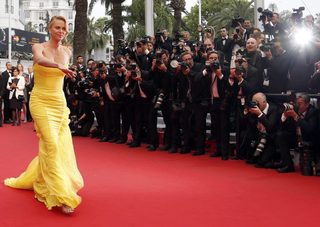 Cast member Charlize Theron poses on the red carpet as she arrives for the screening of the film "Mad Max: Fury Road" out of competition at the 68th Cannes Film Festival in Cannes
