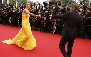 Cast member Charlize Theron and actor Sean Penn pose on the red carpet as they arrive for the screening of the film "Mad Max: Fury Road" out of competition at the 68th Cannes Film Festival in Cannes