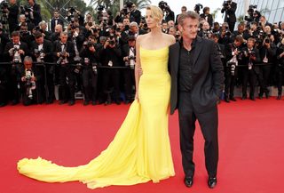 Cast member Charlize Theron and actor Sean Penn pose on the red carpet as they arrive for the screening of the film "Mad Max: Fury Road" out of competition at the 68th Cannes Film Festival in Cannes