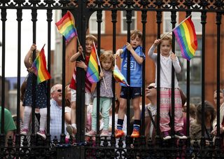 Children wave rainbow flags as they stand with their same-sex marriage supporting parents at Dublin Castle in Dublin