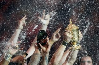 New Zealand's team celebrates with the Webb Ellis trophy after winning the Rugby World Cup Final against Australia at Twickenham in London
