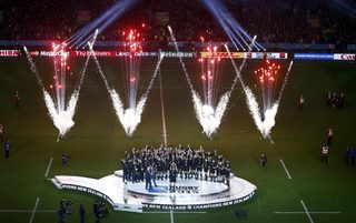 Prince Harry of Britain applauds as McCaw of New Zealand holds up the Webb Ellis trophy after winning the Rugby World Cup Final against Australia at Twickenham in London