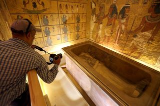 A photographer taking pictures of the golden sarcophagus of King Tutankhamun in his burial chamber is seen in the Valley of the Kings, in Luxor