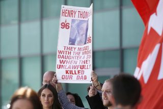 Relatives hold up a banner after the jury delivered its verdict at the new inquests into the Hillsborough disaster, in Warrington, Britain