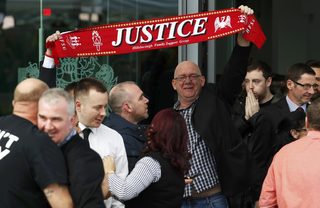Relatives hold up a scarf after the jury delivered its verdict at the new inquests into the Hillsborough disaster, in Warrington, Britain