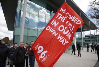 Liverpool fans wave a flag as they wait for the jury deliver its verdict at the new inquests into the Hillsborough disaster, in Warrington