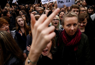 A woman gestures as people gather in an abortion rights campaigners' demonstration to protest against plans for a total ban on abortion in front of the ruling party Law and Justice (PiS) headquarters in Warsaw