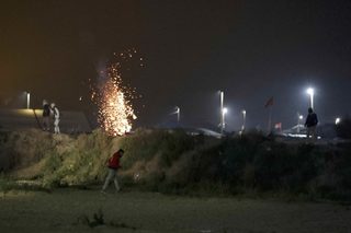 A tear gas cannister from French CRS riot police explodes near migrants on the eve of their evacuation and transfer to reception centers in France, and the dismantlement of the camp called the "Jungle" in Calais