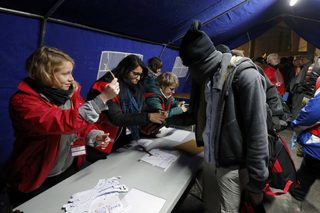 A migrant queues to receive a bracelet at the start of their evacuation and transfer to reception centers in France, and the dismantlement of the camp called the "Jungle" in Calais