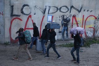 Migrants carry their belongings at the start of their evacuation and transfer to reception centers in France, and the dismantlement of the camp called the "Jungle" in Calais