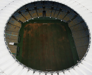 Aerial view of Maracana Stadium shows seats missing and the turf dry, worn and filled with ruts and holes in Rio de Janeiro