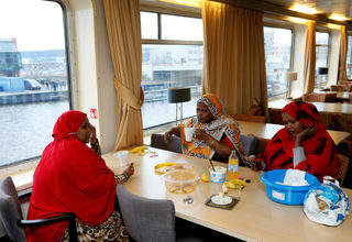 Women from Somalia eat in the common area of a floating hotel in Groningen