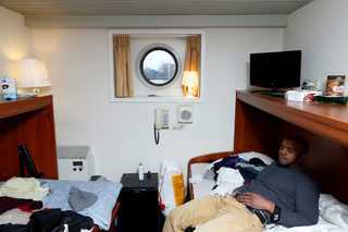 Sall from Guinea rests in one of the cabines of a floating hotel in Groningen