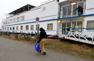 Sall from Guinea walks outside a floating hotel in Groningen
