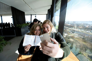 Women take a selfie as they wait in the line to go to vote during the general election inside a polling station on the 20th floor of the ADAM Tower in Amsterdam North
