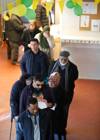 People queue in a polling station during the Dutch general election in The Hague