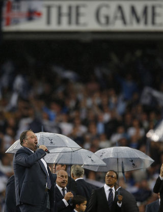Singer Wynne Evans performs as former Tottenham player Edgar Davids looks on during the ceremony after the game