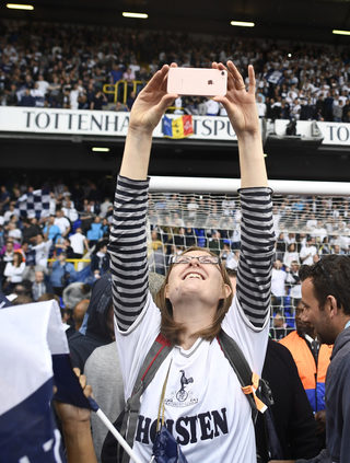 Tottenham fans run on the pitch to celebrate after the match