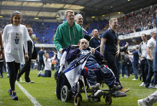 Tottenham fans celebrate on the pitch after the match