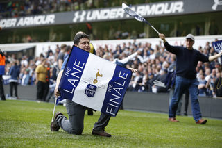 Tottenham fans celebrate on the pitch after the match