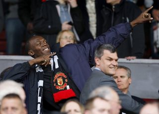 Jamaican sprinter Bolt gestures before Manchester United play Arsenal in their English Premier League soccer match in Manchester