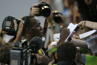 Usain Bolt of Jamaica is surrounded by photographers and well-wishers after he won the men's 100 metres race at the IAAF World Athletics Tour Golden Spike track and field meeting in Ostrava