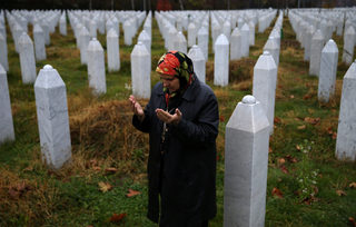 Hatidza Mehmedovic pray near graves of his two sons and husband in Memorial Center in Potocari near Srebrenica