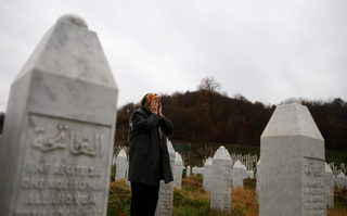 Hatidza Mehmedovic pray near graves of his two sons and husband in Memorial Center in Potocari near Srebrenica
