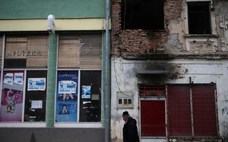 Man passes near by closed pharmacy and shop in Srebrenica