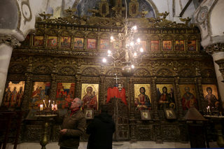 A man lights candles at The Orthodox church of Saint Mary in Labova Kryqit