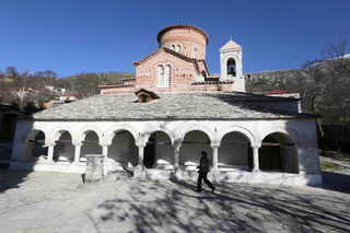 A woman walks in front of The Orthodox church of Saint Mary in Labova Kryqit