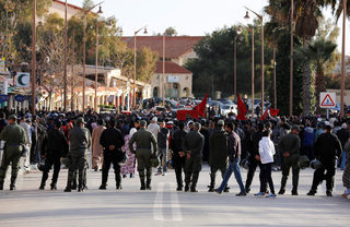 Riot police take their positions to block demonstrators during a protest about the lack of jobs after two miners died while working in a clandestine coal mine, in Jerada