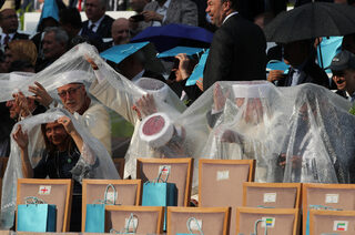 Muftis take cover from the rain as they wait for arrival of Turkish President Erdogan during a ceremony at the Presidential Palace in Ankara
