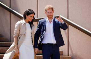 Britain's Prince Harry and wife Meghan, Duchess of Sussex walk during a visit at the Sydney Opera House in Sydney, Australia