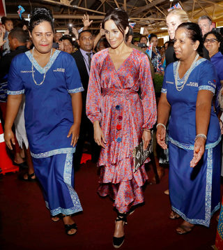 Meghan, Duchess of Sussex, walks with locals during a visit to a market in Suva