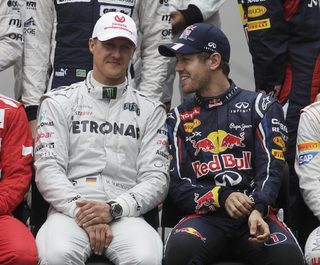 Mercedes Formula One driver Michael Schumacher of Germany and compatriot Red Bull driver Sebastian Vettel sit for a group photo before the Brazilian F1 Grand Prix
