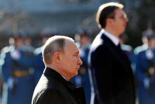 Russian President Vladimir Putin stands next to Serbian President Aleksandar Vucic at Cemetery of Liberators of Belgrade