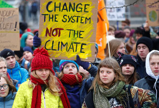People carry a banner reading "Change The System Not The Climate" during the "Fridays for Future" protest against coal and for climate protection in Berlin