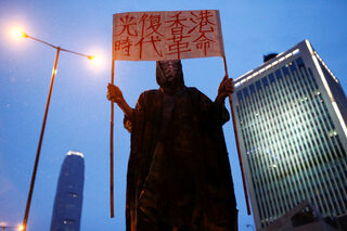 Anti-extradition bill protester holds a placard outside PLA headquarters during a rally in Hong Kong