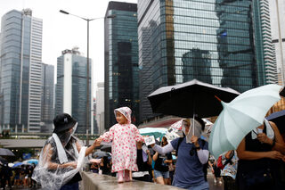 Anti-extradition bill protesters lead a child as they attend a rally in Hong Kong