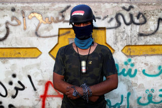 Hussein, an Iraqi demonstrator, poses for a photograph during the ongoing anti-government protests in Baghdad
