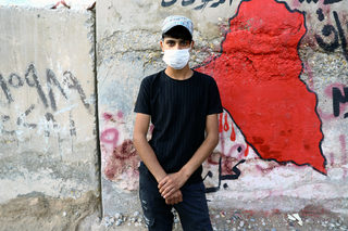 Abadar, an Iraqi demonstrator, poses for a photograph during the ongoing anti-government protests in Baghdad