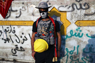 Mohammed, an Iraqi demonstrator, poses for a photograph during the ongoing anti-government protests in Baghdad