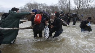 Снимка на деня: Мигранти навлизат в Македония през гранична река